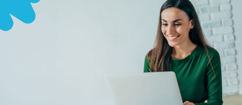 Mujer profesional observa su laptop y sonríe